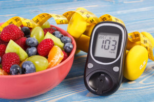 Fruit salad glucose meter centimeter and dumbbells diabetes healthy lifestyle and nutrition concept 983886708 2125x1416